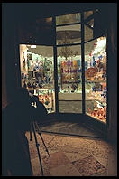 A tourist with a tripod captures a glass shop in Piazza San Marco