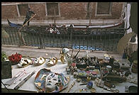 Two Venetian icons in one picture.  Foreground: carnival masks in a shop.  Background:  gondolier.