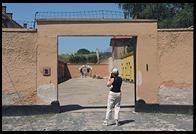 Photographer taking a picture of the courtyard in which the Arbeit Macht Frei arch appears.  Small Fortress.  Terezin