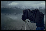 A dedicated view camera user works in a steady rain. Glacier National Park, Montana