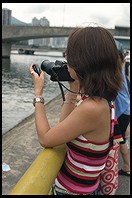 Woman photographing dragon boat racing.  Sha Tin, Hong Kong