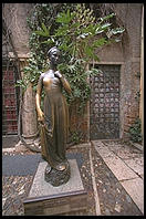 Statue of Shakespeare's Juliet, Verona. Note the shine on her right breast from the rubbing of tourists' hands. Note further the doorway behind the statue where lovers leave notes.